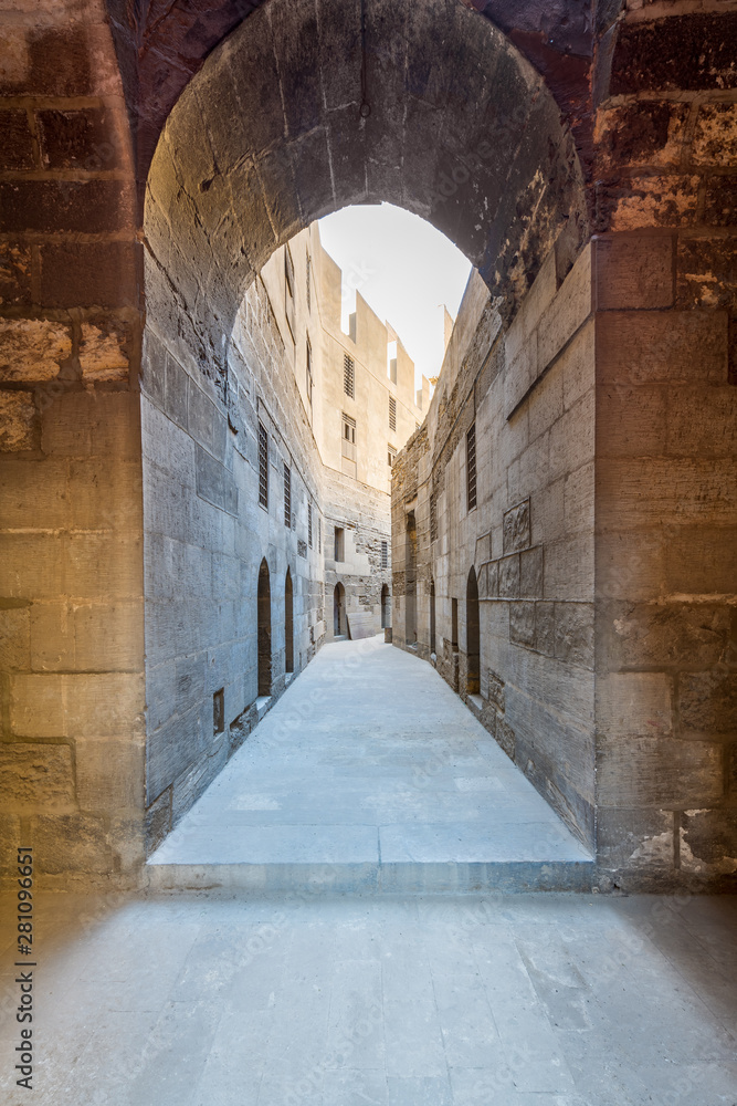 Obraz premium Narrow passage with old grunge stone walls leading to Sultan Hasan Mosque, Cairo, Egypt