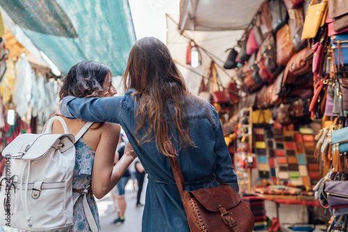 Two young Female Friends Shopping in a Italian Market in Florenc photo