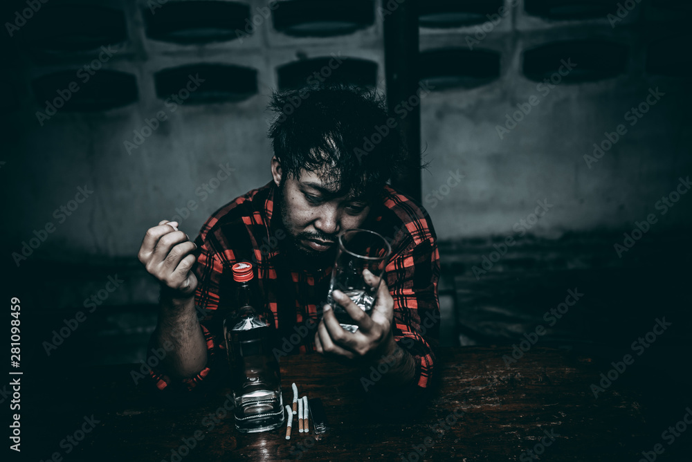 Naklejka premium Asian man drink vodka alone at home on night time,Thailand people,Stress man drunk concept