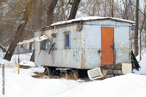 Old, rusty, abandoned wagon or trailer on the outskirts of the city in winter