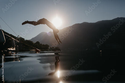 Young man jumping in river photo