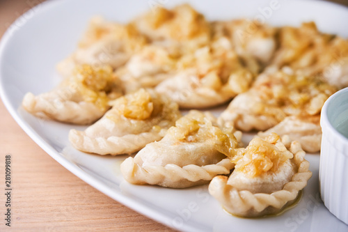 Fried dumplings stuffed with meat carmelized onion on white plate