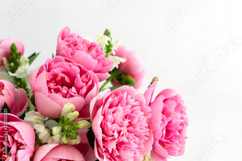 Bouquet of beautiful pink peonies in straw basket