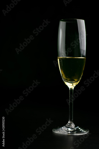 Copa de champaña con fondo negro y bokeh dorado y azul.