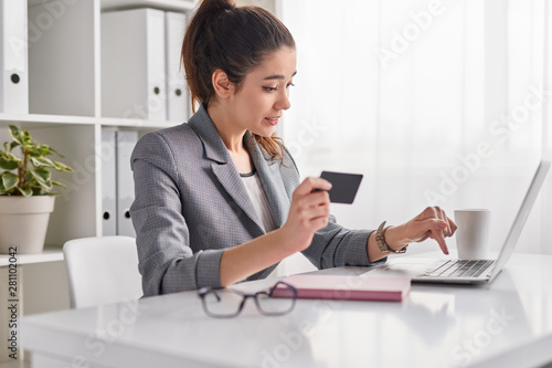 Fotografia Young woman entering credit card credentials for online purchase
