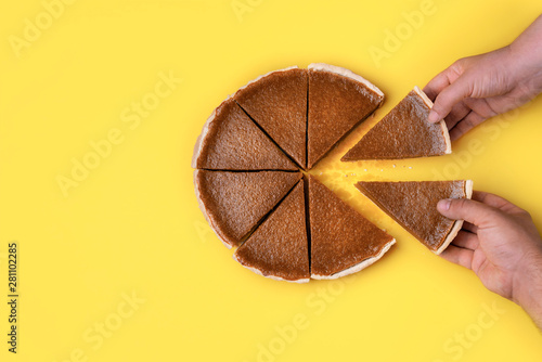 Hands taking pie slices. Eating pumpkin pie photo