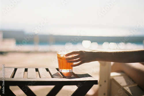 Reaching out for an aperol spritz, with sparkling sea in the background. photo