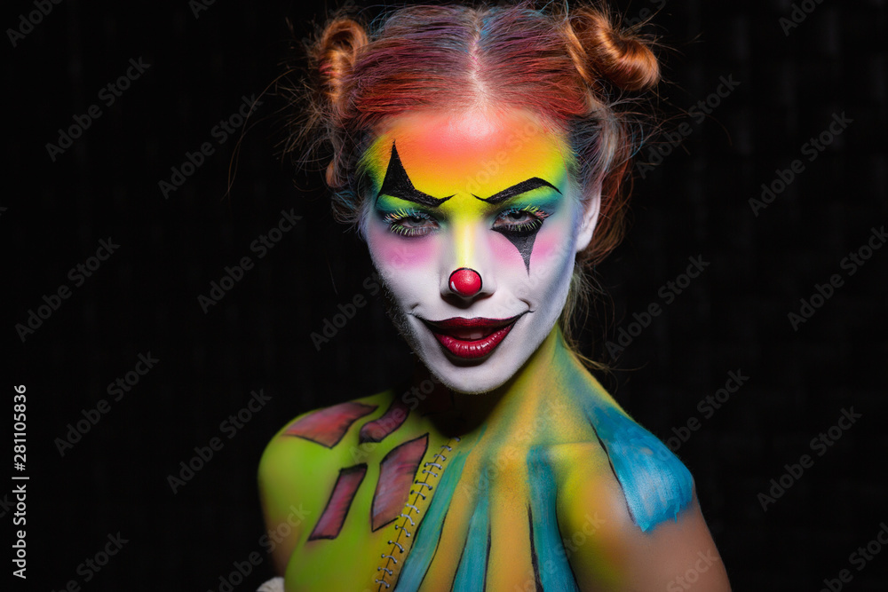 Lovely young woman with a face painting clown.