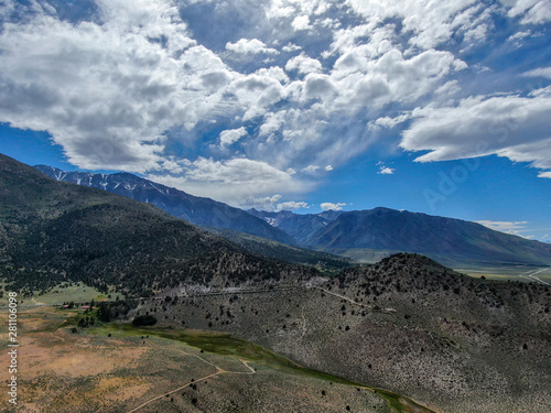 Fototapeta Naklejka Na Ścianę i Meble -  Aerial top view of green land and mountain in the background in Aspen Springs, Mono County California, USA
