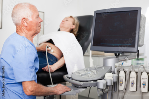 Skilled doctor diagnosing patient using ultrasound scanner