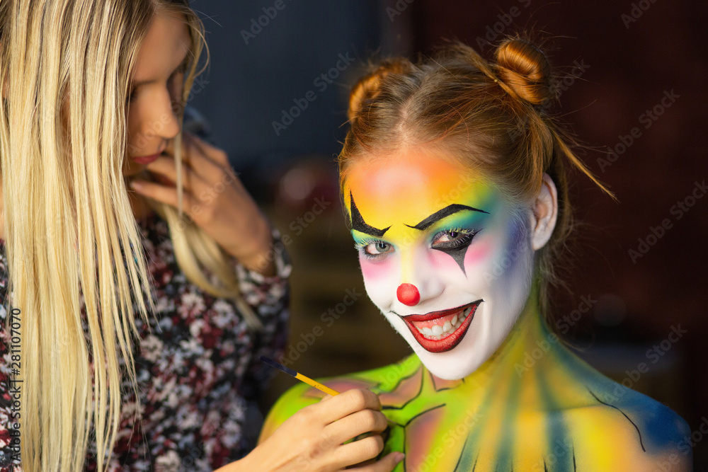 Obraz premium Makeup artis puts a aqua makeup on a attractive lady.