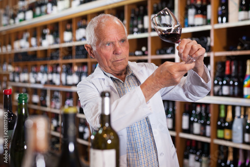 Wine producer inspecting quality of wine