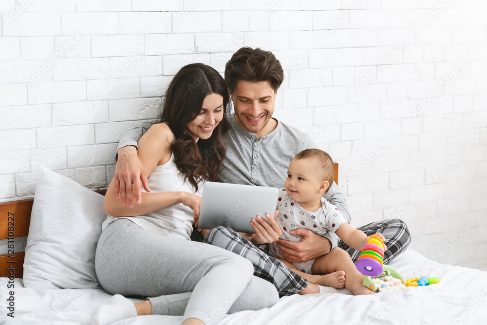 family, parenthood and people concept - happy mother and father showing tablet pc computer to baby at home family, parenthood and people concept - happy mother and father showing tablet pc computer to baby at home