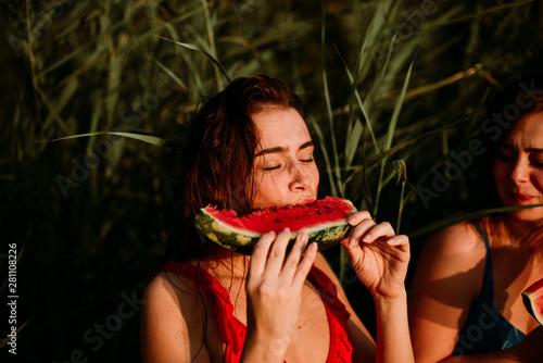 A woman eats a watermelon