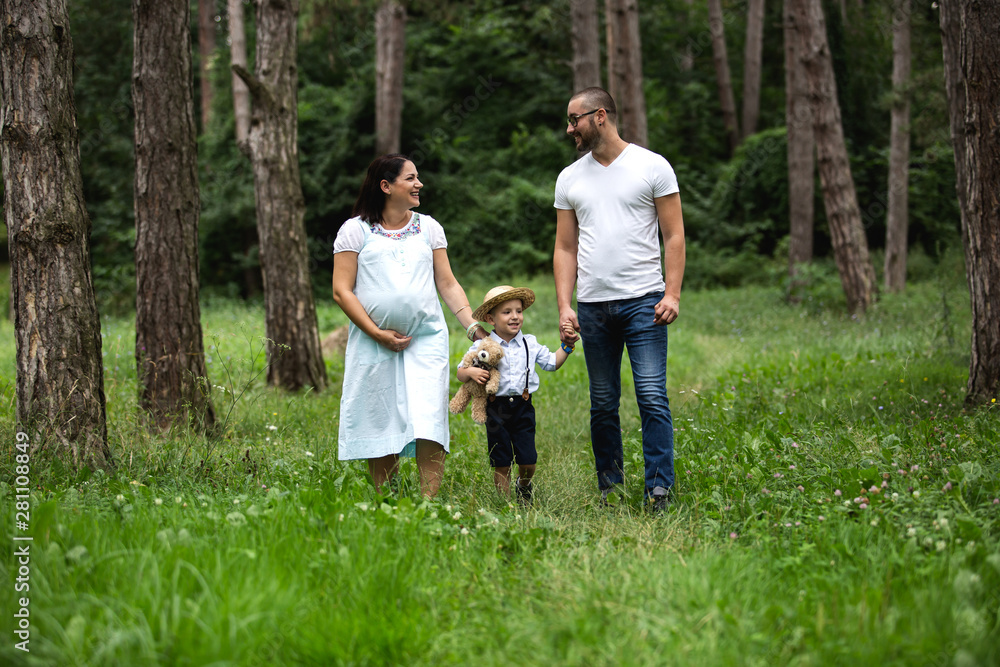 Pregnant young woman with her family in nature