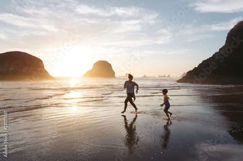 Mother and son enjoying beach during sunset