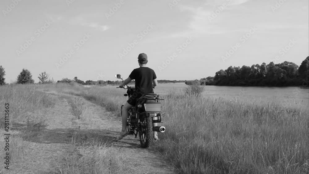 A motorcycle ride parallel to the river in search of a new route, in the open air during summer vacations, the best kind of outdoor activities for people who love nature A motorcycle ride parallel to the river in search of a new route, in the open air during summer vacations, the best kind of outdoor activities for people who love nature