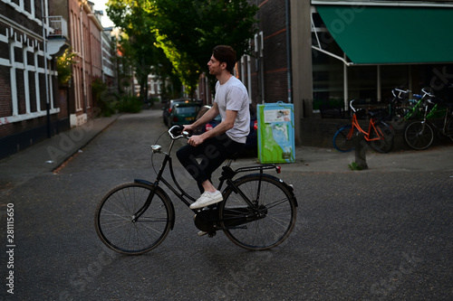 Traveling young man enjoyingly exploring an old town on his bicycle photo