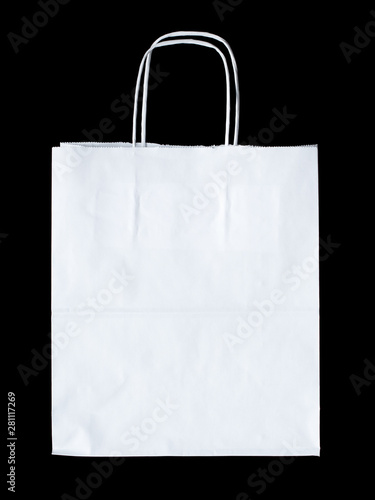 New empty blank paper bag with handles without inscriptions and logos. Made from white kraft paper. Isolated on black background.