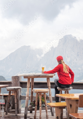 Sporty woman drinking beer in mountain cafe. People and Lifestyles concept. Travel and adventure