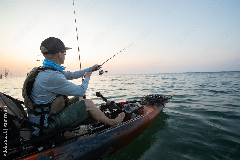 Young Man Kayak Fishing at Sunrise in Canada Young Man Kayak Fishing at Sunrise in Canada