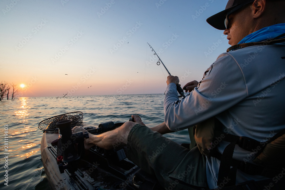 Young Man Kayak Fishing at Sunrise in Canada