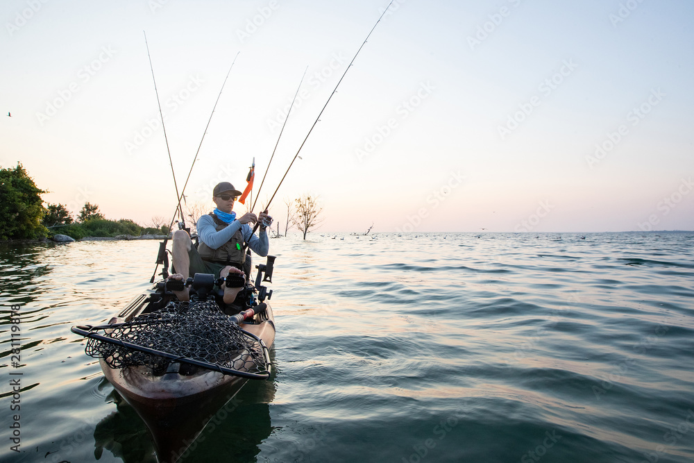 Young Man Kayak Fishing at Sunrise in Canada