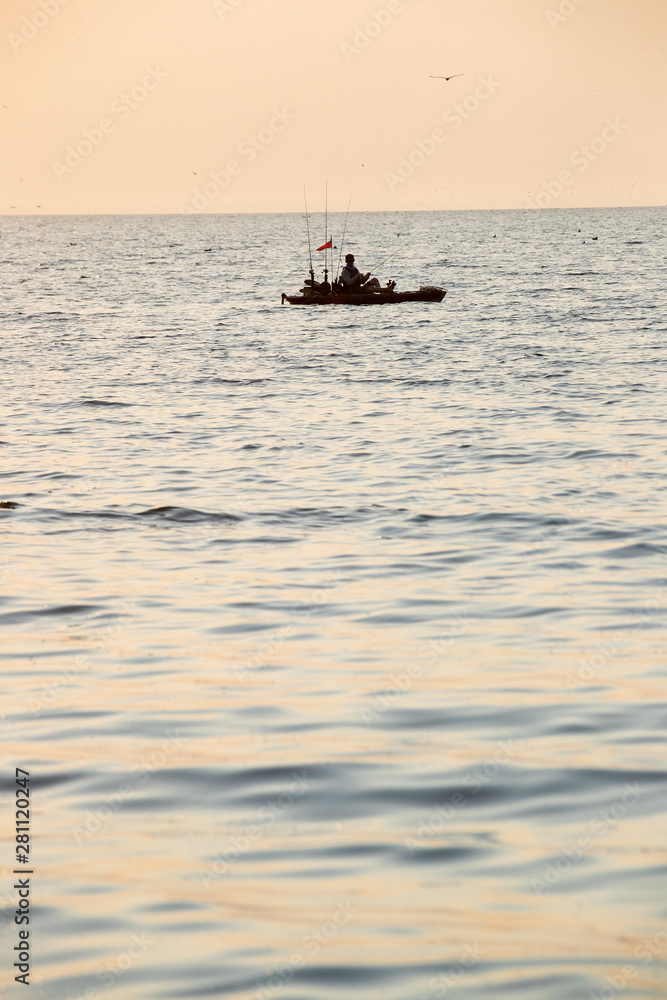 Obraz premium Young Man Kayak Fishing at Sunrise in Canada