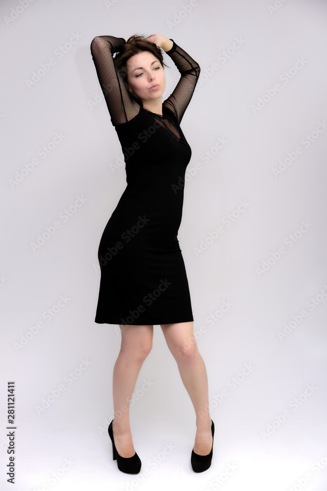 Horizontal Portrait of a pretty slim beautiful fashionable adult girl with beautiful brunette hair in a black dress. It should be in full growth, talking showing different poses and emotions Horizontal Portrait of a pretty slim beautiful fashionable adult girl with beautiful brunette hair in a black dress. It should be in full growth, talking showing different poses and emotions