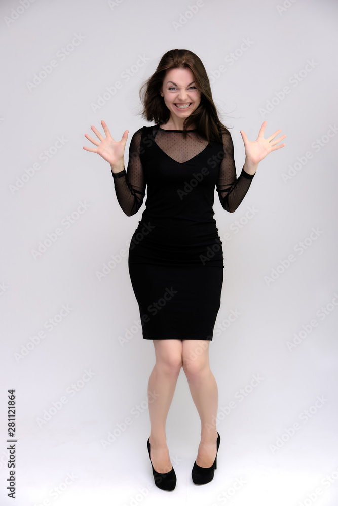 Horizontal Portrait of a pretty slim beautiful fashionable adult girl with beautiful brunette hair in a black dress. It should be in full growth, talking showing different poses and emotions Horizontal Portrait of a pretty slim beautiful fashionable adult girl with beautiful brunette hair in a black dress. It should be in full growth, talking showing different poses and emotions