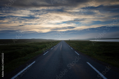 Country road across the tundra landscape in summer night. Finnmark, Norway