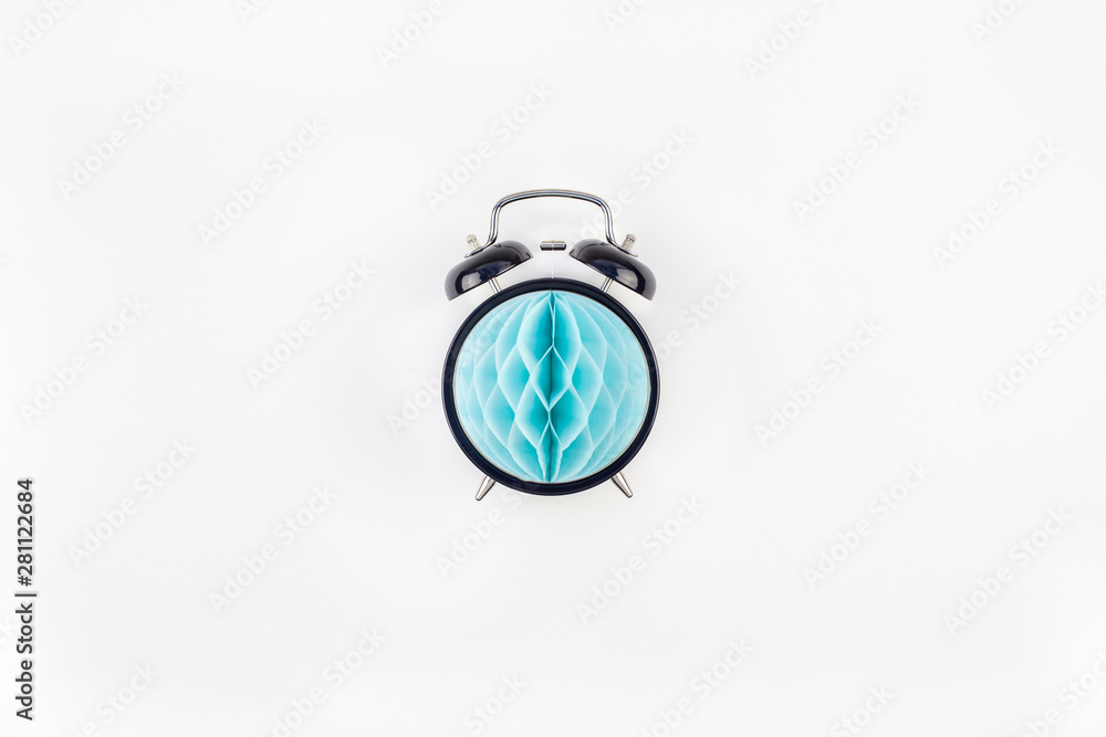 Black alarm clock with blue paper ball concept Black alarm clock with blue paper ball concept