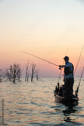 Young Man Kayak Fishing at Sunrise in Canada © Colin