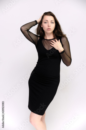 Horizontal Portrait of a pretty slim beautiful fashionable adult girl with beautiful brunette hair in a black dress. It should be in full growth, talking showing different poses and emotions © Вячеслав Чичаев