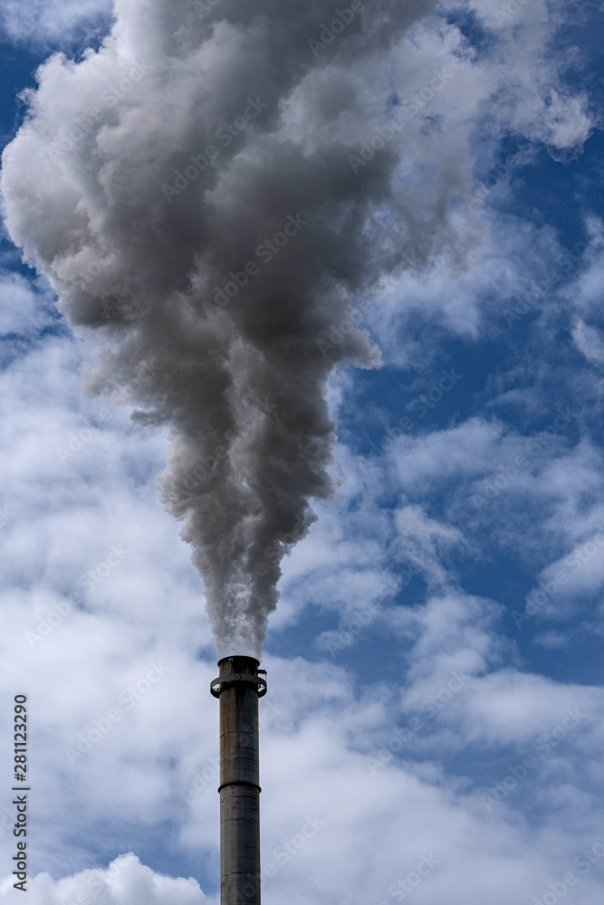 Qualmender Schornstein vor blauem Himmel Qualmender Schornstein vor blauem Himmel