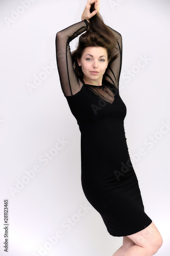 Horizontal Portrait of a pretty slim beautiful fashionable adult girl with beautiful brunette hair in a black dress. It should be in full growth, talking showing different poses and emotions