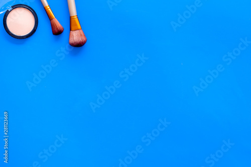 Brushes for make up, powder on blue visagiste work desk background top view copyspace photo