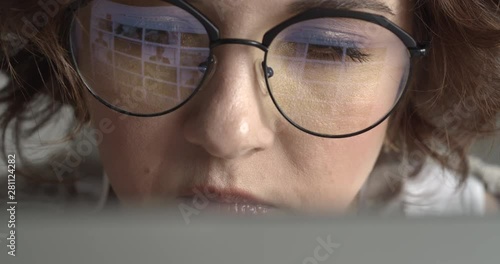 Attractive Young Hipster Girl Working at her Computer. Young woman surfing the internet looking for perfect content