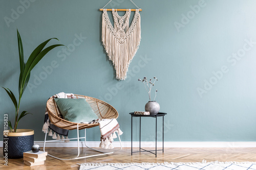 Boho style living room with rattan armchair, macrame and exotic plant photo
