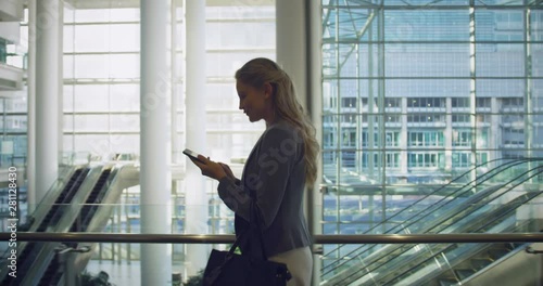 Businesswoman talking on mobile phone in the lobby at office 4k photo
