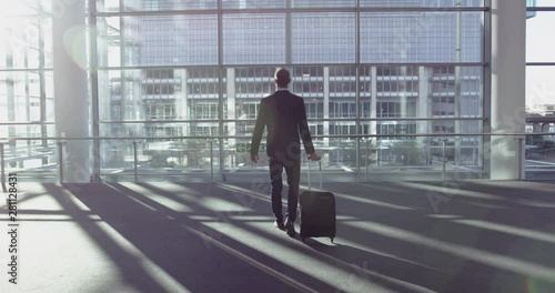 Businessman standing with luggage in the lobby at office 4k photo