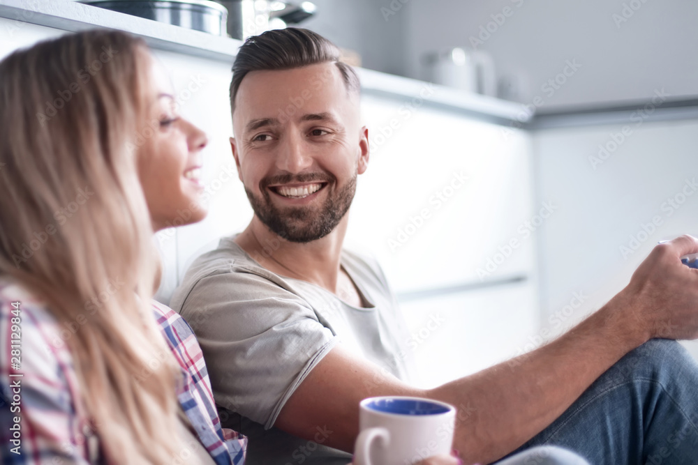 loving couple talking, sitting in the kitchen on the floor loving couple talking, sitting in the kitchen on the floor