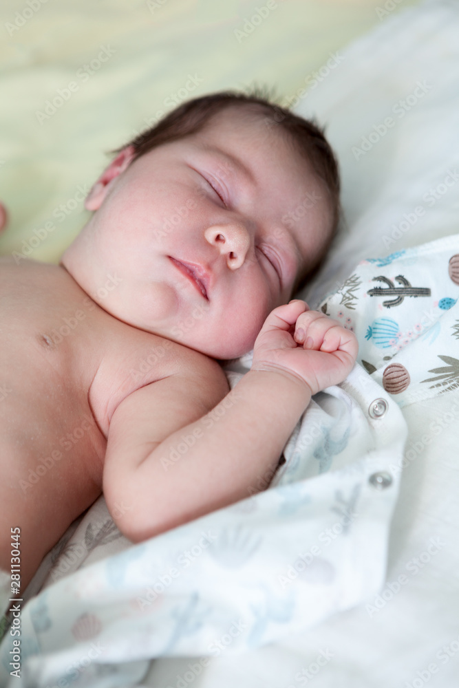 Sweet one month old newborn baby sleeping on her back in her crib, hand up Sweet one month old newborn baby sleeping on her back in her crib, hand up