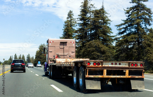 Semi truck on highway with empty flatbed trailer. photo