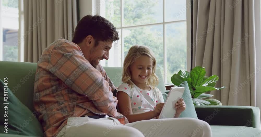 Father and daughter using digital tablet on sofa at home 4k Father and daughter using digital tablet on sofa at home 4k