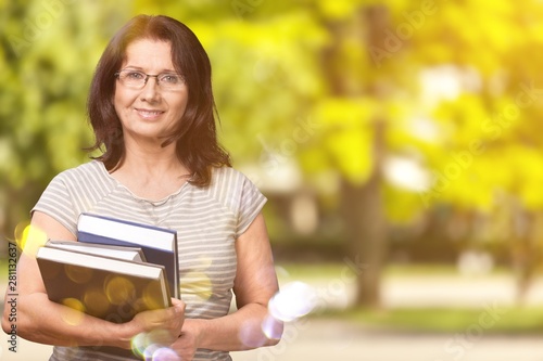 Mature woman teacher with books on background