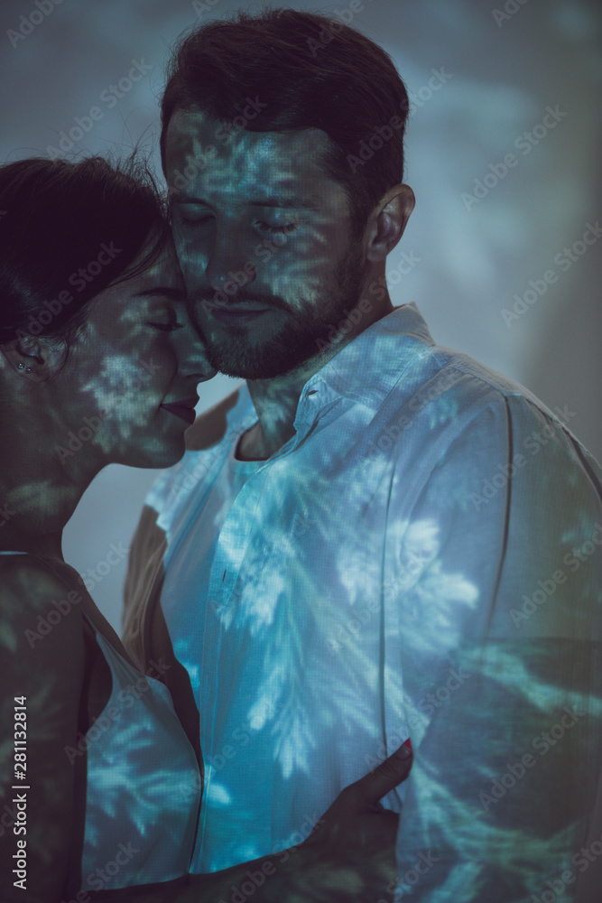 two people in love hugging while standing on dark place two people in love hugging while standing on dark place