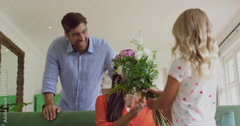 Girl giving flower bouquet to her mother in living room at home 4k Girl giving flower bouquet to her mother in living room at home 4k