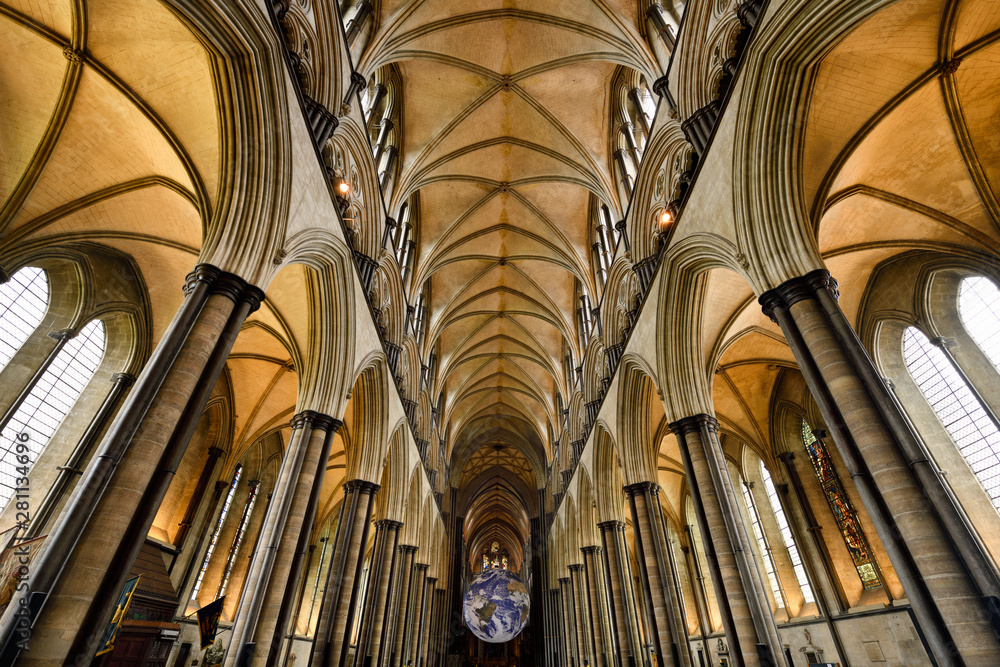 Vaulted ceiling of nave with pillars and upper clerestory of medieval Salisbury Cathedral looking to the front with spinning globe Salisbury England