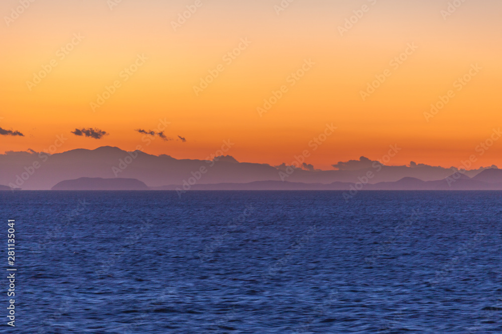 Beautiful sunset with orange sky with Aegean Sea islands background Beautiful sunset with orange sky with Aegean Sea islands background